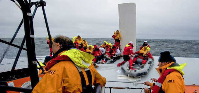 Die irischen Retter bergen die einzelnen Crewmiglieder mit einem Gummiboot vom umgedrehten Rumpf der "Rambler". © RNLI