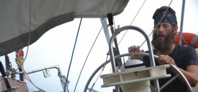 Skipper Ben Schaschek steuert durch einen Sturm. Vor dem Törn hat er nie auf hoher See gesegelt. © sailingconductors.com