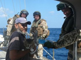 Soldaten der Bundesmarine bringen dem italienischen Segler mit Katze Sprit an Bord. © Bundeswehr/Pressestelle Djibouti