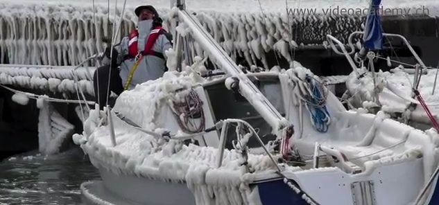 Eingepickt mit der Lifeline begutachtet ein Eigner den Eispanzer auf seinem Boot in Versoix am Genfer See.