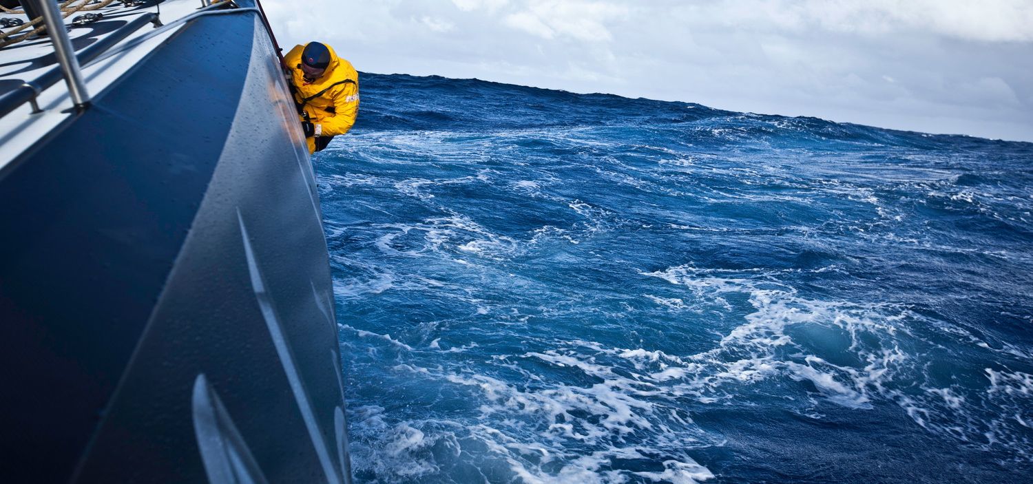 Abu Dhabi Vorschiffsmann Justin Slattery hängt außenbords, und steckt 30 Schrauben durch den Rumpf. © Nick Dana/Abu Dhabi Ocean Racing/Volvo Ocean Race