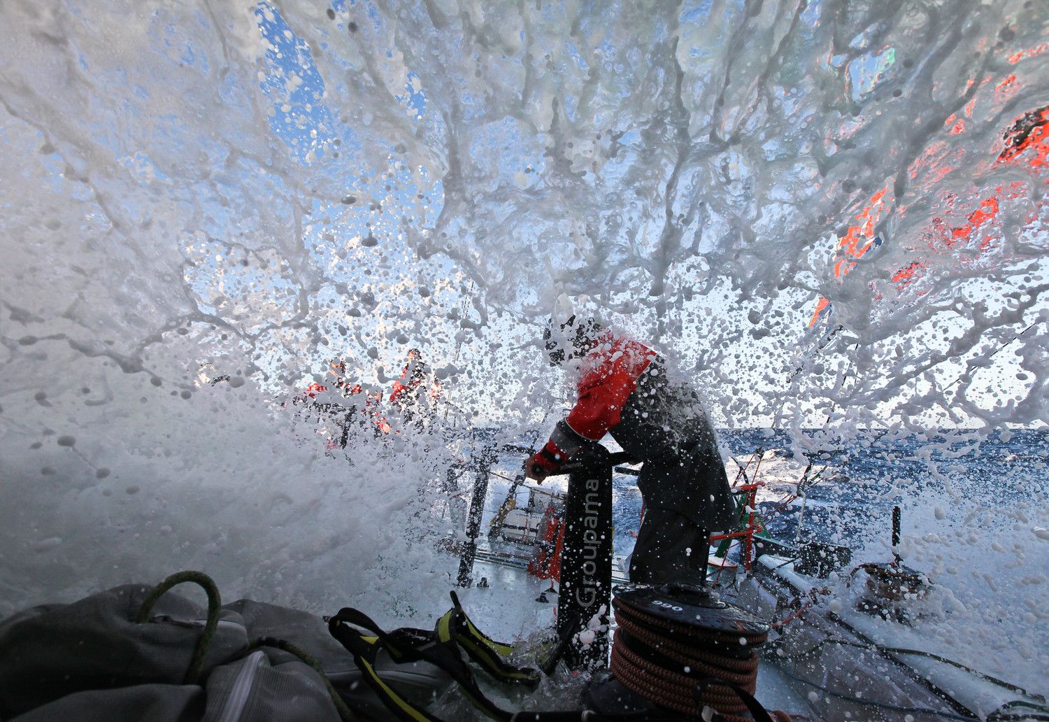 ...gut zurecht. Der langjährige Match Racer Erwan Israel hält der Dusche am Grinder klaglos stand. Seit Tagen... © Yann Riou/Groupama Sailing Team/Volvo Ocean Race