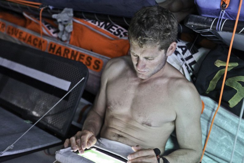 Charles Caudrelier schreibt Emails von Bord der Groupama  und zeigt seinen Waschbrettbauch. © Yann Riou/Groupama Sailing Team/Volvo Ocean Race