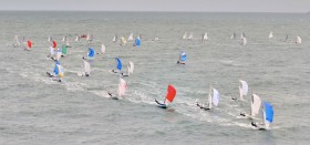 Fiven-Flotte auf dem finalen Vorwindkurs auf dem grauen Traumrevier. Die Vorschoter stehen im Trapez. © Christophe Favreau