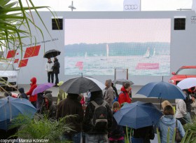 Selbst bei Regen ist die Audi-Bühne, wo die Rennen live kommentiert werden, gut besucht. © Marina Könitzer