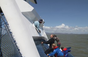 Der 50-Fuß-Kat "eDoc" liegt auf der Seite, die Familie steht auf dem Leeschwimmer, der Vater sieht aus der Fluchtluke. © Sealink Magnetic Island Race Week Media