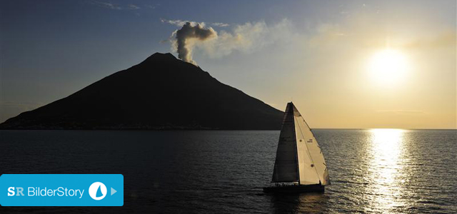 Die 21 Meter Yacht "Allegre" vor dem Stromboli mit einem drohenden Wölkchen über dem Gipfel. © Rolex / Kurt Arrigo