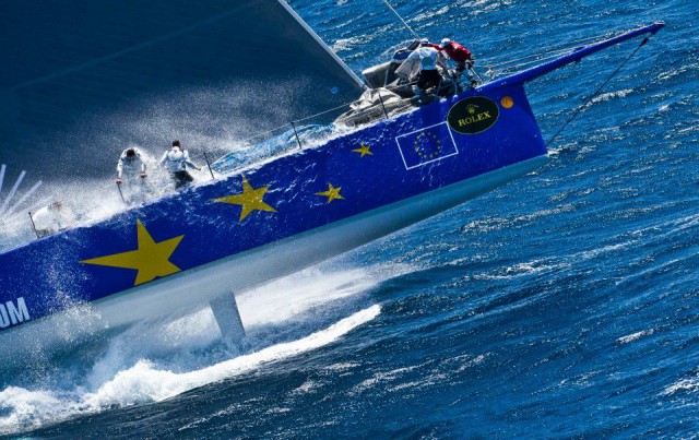 `Esimit Europa 2´ hebt eindrucksvoll in einer Welle ab. Das Canard-Schwert ist zu sehen, das dem Neigekieler gegen die Abdrift hilft. © Rolex 