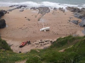 Neben dem gestrandeten Mini ist auch das gekenterte Motorboot angespült worden, das die Yacht vom Strand ziehen sollte. © Le Clech Mini 6.50 gestrandet