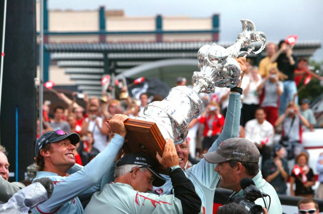 Schümann (halb hinter der Kanne) nach dem Sieg beim 32. America’s Cup mit Alinghi. © Thierry Martinez Schümann (halb hinter der Kanne) nach dem Sieg beim 32. America's Cup mit Alinghi