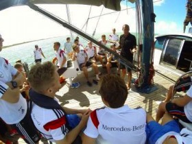 Die DFB Kicker lauschen Mike Horn. Schürrle mit Schwimmweste – Großkreuz dreht dem Abenteurer den Rücken zu. DFB Team Mike Horn
