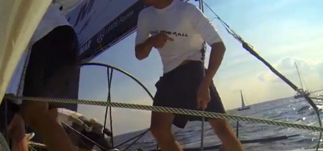 Ein One4All Cremitglied versucht vorsichtig darauf aufmerksam zu machen, dass sein Shirt im Großschotblock hängt. IMMAC Outtakes