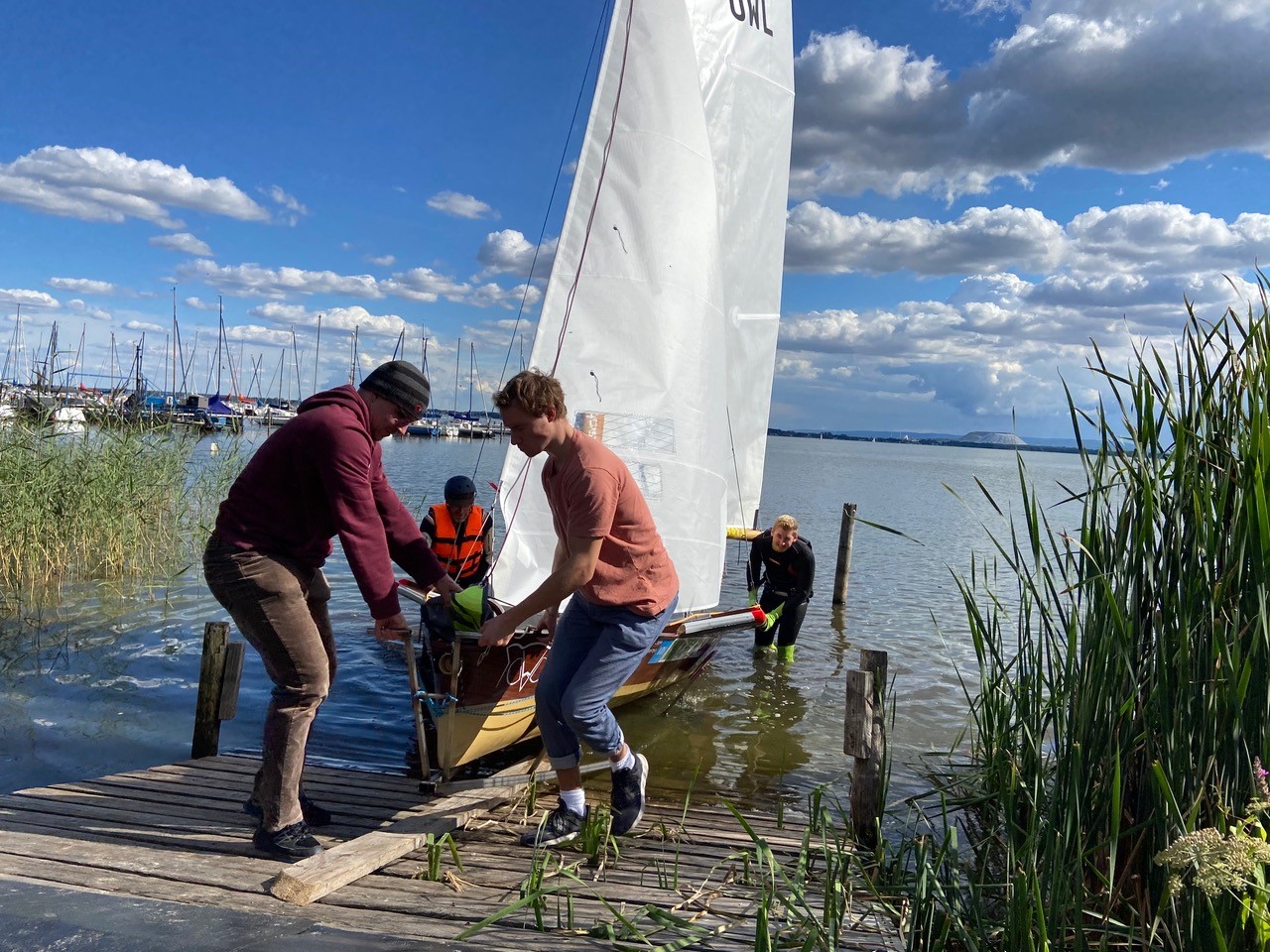Steffen Wenk, Professor Adrian Riegel, Justus Doerfert und Sebastian Plate (v.l.) holen ihr Skiff nach erfolgreicher Jungfernfahrt auf dem Steinhuder Meer aus dem Wasser © TH OWL, Pia Schlegel