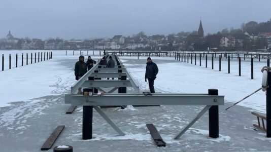 Gemeinschaftsarbeit im Hafen: Wie die zugefrorene Schlei hilft, einen neuen Vereinssteg zu bauen